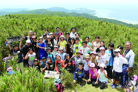 於茂登岳山頂で記念撮影する参加者一同=26日、午後
