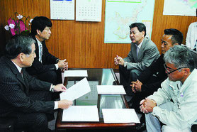 石垣島に軍事基地をつくらせない市民連絡会のメンバーや川原公民館の具志堅館長(右側中央)が漢那副市長(左側手前)に要請書を提出した=15日午前、市役所