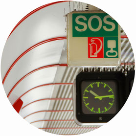 Uhr und eine SOS Schild in einem U-Bahnhof