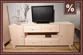 Niedriges TV-Board aus hellem Holz mit Fernseher. Prozentzeichen.