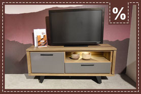 Niedriges Sideboard aus Holz mit grauer Verkleidung und einem beleuchteten Fach. Prozentzeichen.