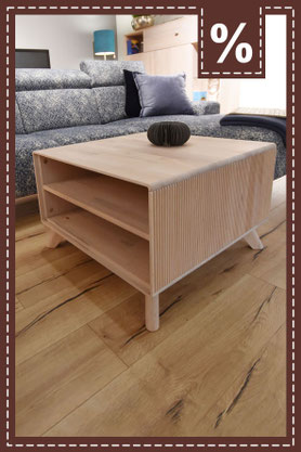 Couchtisch aus hellem Holz mit gerillten Seitenwänden und offenen Fächern. Prozentzeichen.