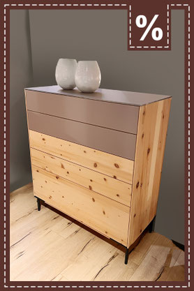 Kommode aus hellem Holz mit zwei beigefarbenen Schubladen und zwei weißen Vasen oben. Prozentzeichen.