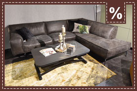 dunkelgraues Ledersofa mit einem bunten Zierkissen