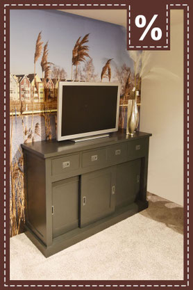 Dunkelgraues Sideboard mit Schiebetüren und einer Tapete mit Meerblick dahinter. Prozentzeichen.
