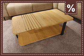 Couchtisch mit zwei Platten aus Eichenfurnier und 3 schwarzen Tischbeinen auf hellem Teppich 