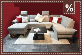 hellgraues Sofa mit roten und silbernen Zierkissen 