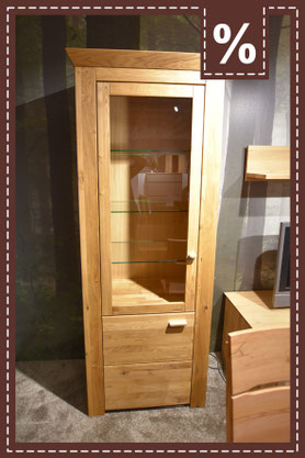 Hohe Vitrine aus Holz mit Glasfront und drei Glasböden. Prozentzeichen in der Ecke.