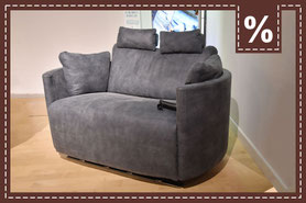 Graues Zweisitzersofa mit verstellbaren Kopfstützen und Prozentzeichen in der Ecke.