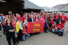 Les bénévoles et des élus de la Manche devant le drapeau normand