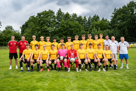 Junge schießt Ball zum Trainer