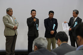 登壇し、家族への思いを語った家族ら(写真左から1人目から3人目)と藤田氏=25日、産業振興センター
