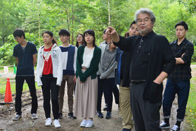 買収された赤井川村のキャンプ場でツアー参加者に解説する宮本編集委員(手前右)