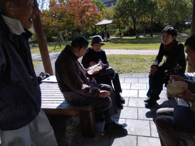 阪大病院の庭園内のベンチで語り合う先生と会員たち。