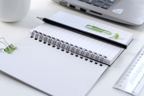 Ein Notizbuch, ein Taschenrechner und ein Stift.