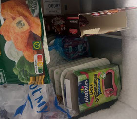 Ein Foto des Inhaltes der geöffneten Tiefkühltruhe. Zu sehen ist eine Packung mit Kartoffeltaschen und eine mit Wassereis.