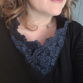 Sur l'image, un pull noir qui était un col roulé et qui a été transformé en haut avec un col en dentelle bleu canard.