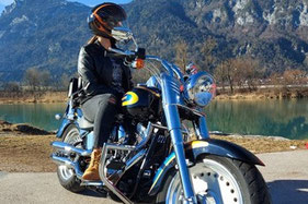Motorradfahrer auf einem blauen Custom-Bike vor Bergpanorama in Tirol