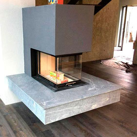 Steinmetzbetrieb: Moderner, mit Naturstein verkleideter Kamin in einem Wohnraum