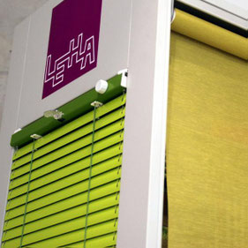 Sonnenschutz: Grüne und gelbe Außen-Raffstores als moderner Sonnenschutz an einer Hausfassade