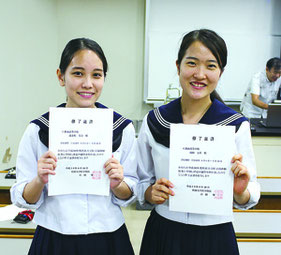 修了証書を手に笑顔を見せる渡嘉敷さん(写真左)と山田さん。医学部進学の夢を膨らませた=10日、琉球大学