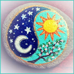 Bemalter Stein mit Sonne und Mond