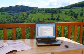 Ordianteur sur une terrasse face à la nature