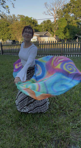 Woman dancing with a very colorful silk viel