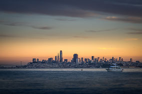 Die erleuchtete Skyline von San Francisco bei Abenddämmerung von Sausalito aus fotografiert.