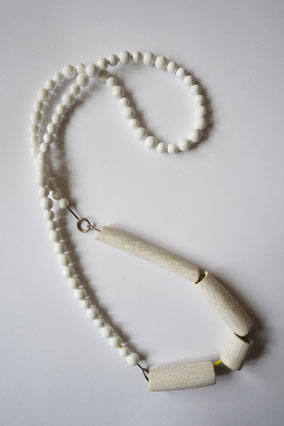 Kascholongkette mit vier hellen Keramikelementen auf gelbem Poundbeadstrang.