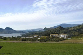 Blick auf ein Hotel am See umgeben von Bergen auf der Rundreise durch Andalusien