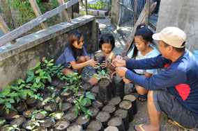 Local staff teaching children seedling making at the Abra Agro/Forestry Center
