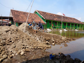 Landfill work in the schoolyard where seawater has accumulated