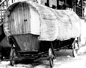 Oude paardenwagen met overkapping. Zwart-wit foto.