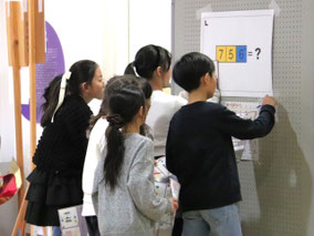 PTA行事で、張り出された掲示物を見て謎を解く子どもたちの様子
