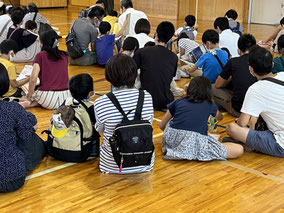 PTA親子行事で謎解きゲームを行い体育館に集まっている様子