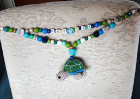 Kinderwagenkette aus Holzperlen speichelecht mit handgefertigter Schildkröte mit Rassel. Handarbeit von Bijou Chien