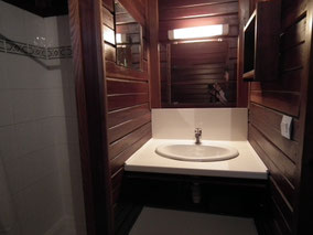 Bungalow n°1 - Salle de ban complète avec lavabo, douche, serviettes et tapis de bain