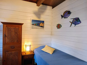Living area with single bed, TV, storage and bed linen – Bungalow No.1, Réunion Island