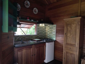 Equipped kitchenette of T1 bungalow #2 – extractor hood, gas hob, fridge, microwave
