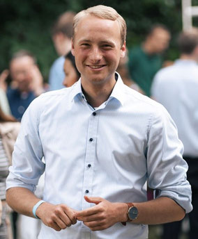 Portraitfoto von Konrad Schepers in einer Gruppe von Menschen.