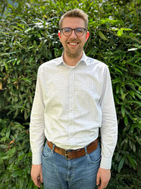 Portraitfoto von Raphael Ronge vor grünem Hintergrund.