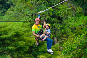 Familia con niños disfrutando del canopy en Arenal Ecoglide, una experiencia segura y divertida en el bosque tropical cerca del Volcán Arenal.