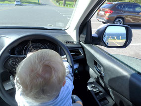 Auch Babys haben bei der Autofahrt gerne alles selbst im Griff!