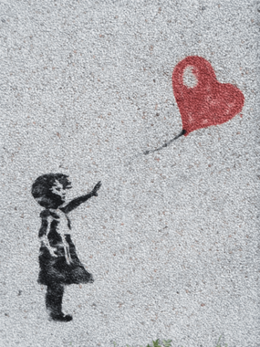 Ein Mensch, der einen Herzluftballon loslässt - loslassen muss. Manche Dinge, an denen unser Herz hängt, müssen wir loslassen-fliegen lassen,  obwohl wir es gar nicht wollen.