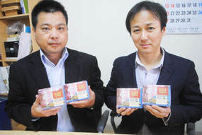 ANAで機内販売される「石垣の塩ちんすこう」を手にする宮城代表取締役(右)と喜舎場統括部長=28日午前、宮城菓子店
