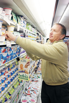 RandY Bender, owner of Bender’s Foods in Bellevue, faces stock in the dairy section of the store, which first opened in 1991.