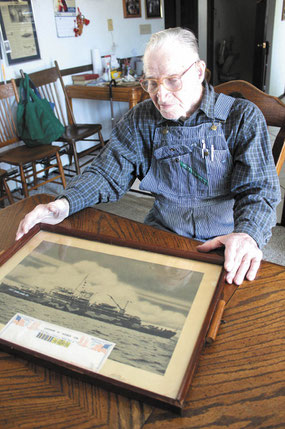 Vernon Weber of St. Donatus displays a photo of his seapleane tender, the USS Shelikof on which he served aboard during Pacific Theatres battles in World War II.