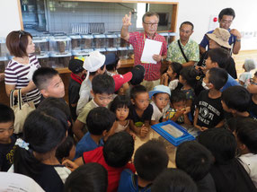 昆虫館の山田館長から育て方の説明を聞く子どもたち=23日午後、バンナ公園
