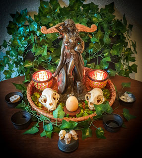 Altarbild mit der Göttin Freya, Efeu, Osterei aus gelben Jaspis, kleinen künstlichen Menschenschädeln und echten Katzenschädeln, Opferschälchen für die Elemente.